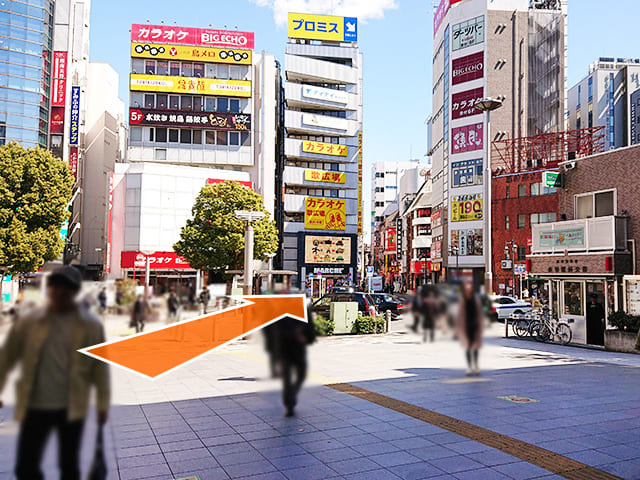 やや右斜め前方向（歌広場と魚民のビルの間）に向かいます。